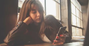 Chica consultando un móvil distraída