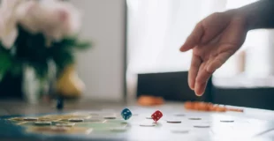 Mano lanzando un dado sobre un tablero