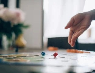 Mano lanzando un dado sobre un tablero