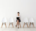Mujer a la espera de entrevista de trabajo, sentada en el centro de la imagen