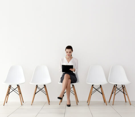 Donna in attesa di un colloquio di lavoro, seduta al centro dell'immagine