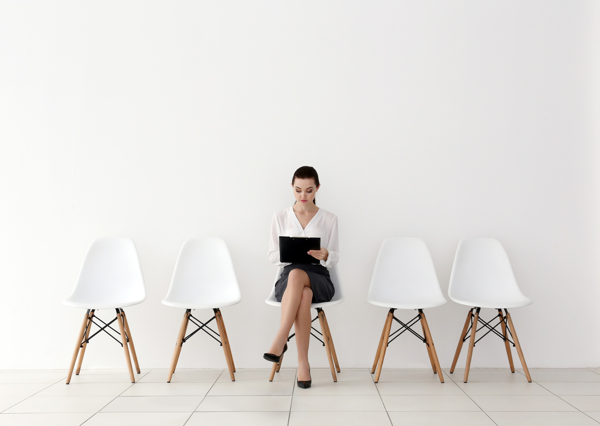 Mujer a la espera de entrevista de trabajo, sentada en el centro de la imagen