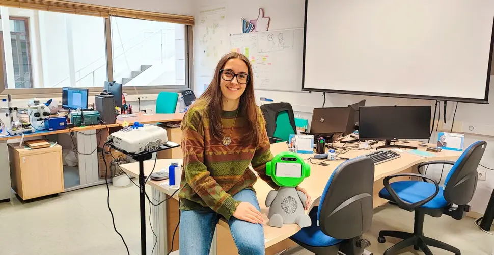 Laura Villa sentada sobre una mesa en un laboratorio de Investigación