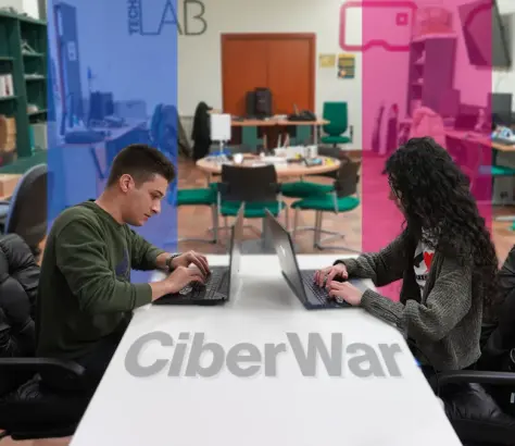 dos estudiantes en el laboratorio enfrentados a través de un computador