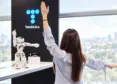 Mujer frente a robot y logo de telefónica
