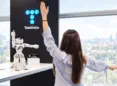 Mujer frente a robot y logo de telefónica
