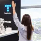 Mujer frente a robot y logo de telefónica